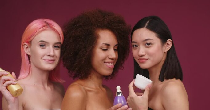 Cheerful multiracial models show skincare cosmetic products