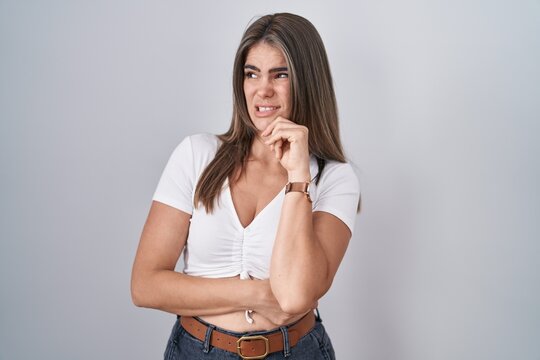 Young beautiful woman wearing casual white t shirt thinking worried about a question, concerned and nervous with hand on chin