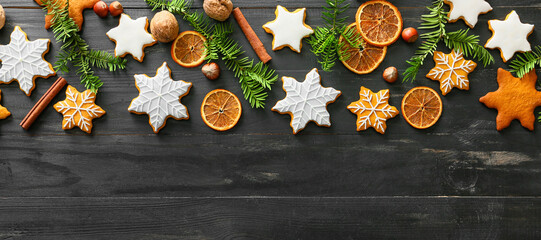 Banner with tasty Christmas cookies, cinnamon and dry orange slices on dark wooden background