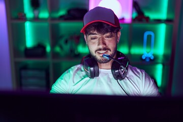 Young hispanic man streamer smiling confident using computer at gamin room