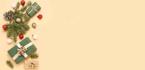 Christmas gift boxes, balls and fir branches on beige background with space for text, top view