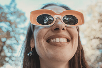 young woman with yellow glasses smiling