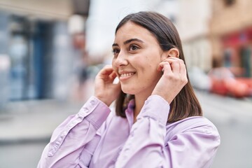 Young hispanic woman smiling confident standing at street