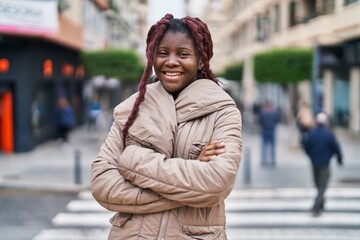 African american woman standing with arms crossed gesture at street