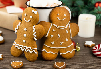 Gingerbread man and gingerbread woman on the background of Christmas decorations. Close up.