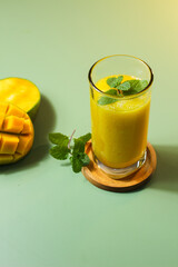 Fresh Mango Juice. Served with a natural green background color along with sliced ​​Arumanis mango.