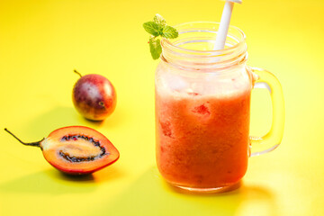 Tamarillo juice or Dutch Eggplant with the Latin name Solanum betaceum with a yellow background. It tastes fresh and unique.