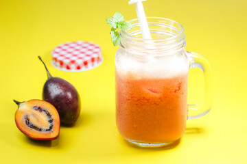 Tamarillo juice or Dutch Eggplant with the Latin name Solanum betaceum with a yellow background. It tastes fresh and unique.