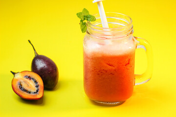 Tamarillo juice or Dutch Eggplant with the Latin name Solanum betaceum with a yellow background. It tastes fresh and unique.