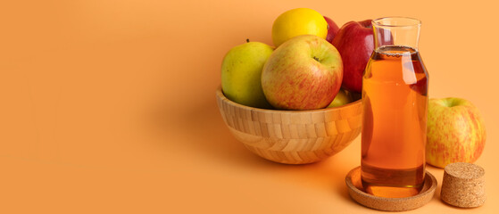 Bowl with ripe apples and bottle of fresh juice on orange background with space for text