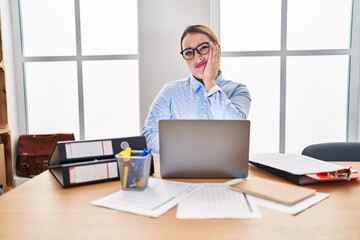 Young hispanic woman working at the office wearing glasses thinking looking tired and bored with depression problems with crossed arms.