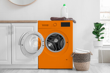 Interior of kitchen with modern orange washing machine