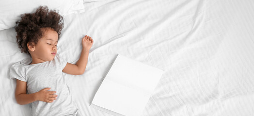 Little African-American girl with book sleeping on bed, top view