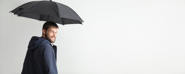 Handsome bearded man holding umbrella on white background with space for text © Pixel-Shot