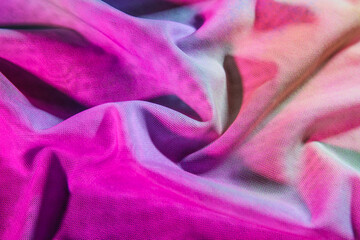 Crumpled fabric in neon light as background