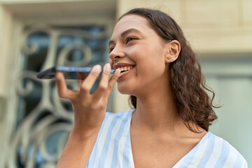 Young african american woman smiling confident talking on the smartphone at coffee shop terrace