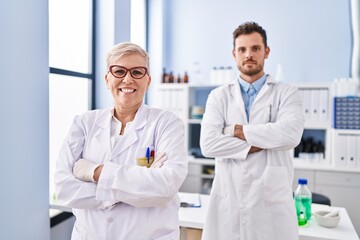 Mother and son scientist partners standing with arms crossed gesture at laboratory