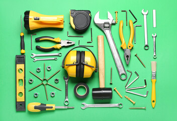 Hearing protectors with builder's tools on green background