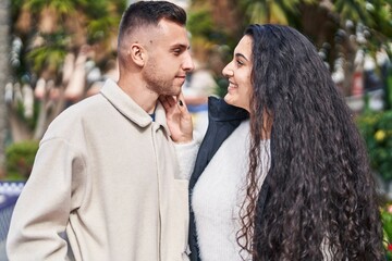 Fototapeta premium Man and woman couple smiling confident standing together at park