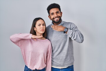 Young hispanic couple standing together cutting throat with hand as knife, threaten aggression with furious violence