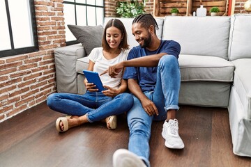 Man and woman couple smiling confident using touchpad at home