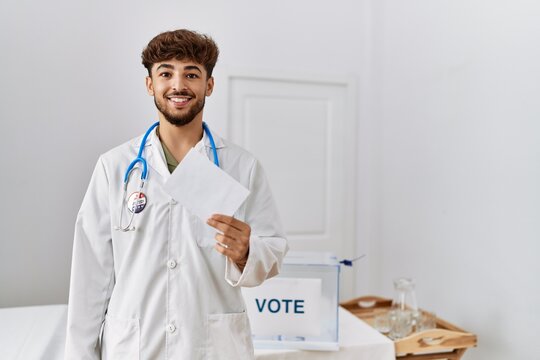 Young arab man wearing doctor uniform holding vote at electoral college