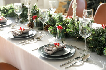Christmas table setting with fir branches and rowan in dining room