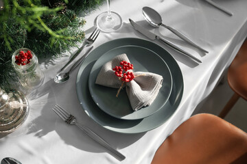 Christmas table setting with rowan berries in dining room, closeup