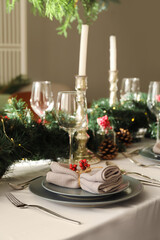 Christmas table setting with fir branches and rowan in dining room