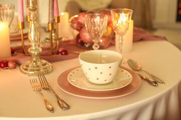Christmas table setting with pink and white plates in dining room, closeup