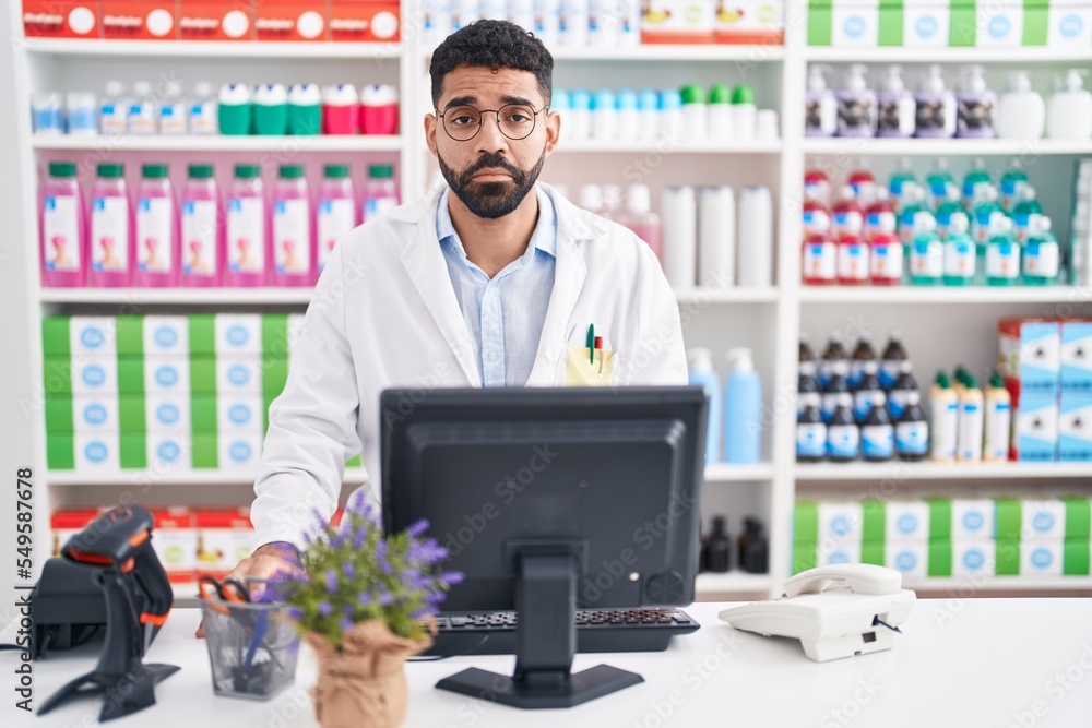 Poster Hispanic man with beard working at pharmacy drugstore depressed and worry for distress, crying angry and afraid. sad expression.