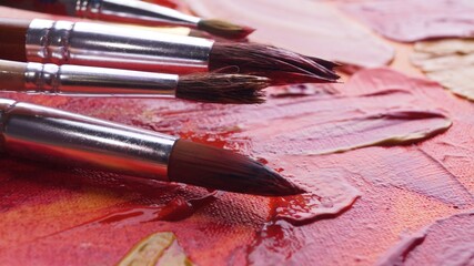 Obraz premium Many brushes on artist's palette with mixed paints, closeup