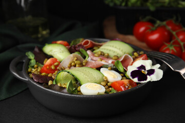 Bowl of salad with mung beans on black table, closeup