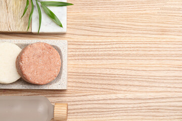 Solid shampoo bars on wooden table, flat lay. Space for text