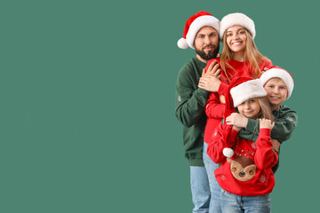 Happy family in Santa hats hugging on green background