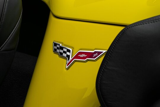 Closeup of the badge of a yellow Corvette C6 Grand Sport between its seats