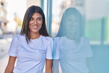 Fototapeta premium Young beautiful hispanic woman smiling confident looking to the side at street