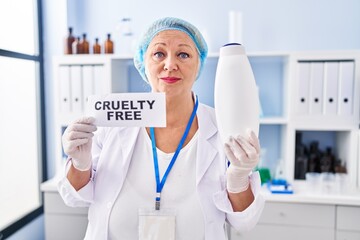 Middle age caucasian woman working on cruelty free laboratory relaxed with serious expression on...
