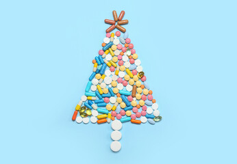 Christmas tree made of pills on blue background