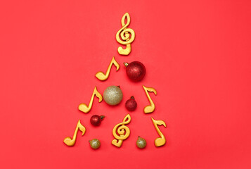Christmas tree made of note signs and balls on red background
