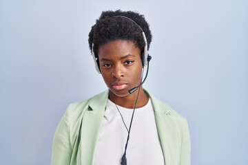 African american woman wearing call center agent headset looking sleepy and tired, exhausted for fatigue and hangover, lazy eyes in the morning.