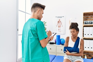 Obraz premium Man and woman wearing physiotherapist uniform having rehab session at physiotherapy clinic
