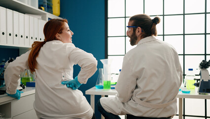 Obraz premium Man and woman wearing sciencist uniform speaking at laboratory