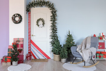 Interior of hall with white door, Christmas decor and armchair