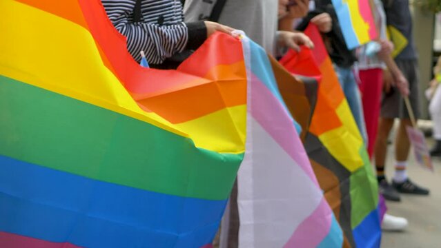 Rainbow flag. People take in hand love banner on pride parade. Equality and protect human rights for LGBT community - KHARKIV, UKRAINE - SEPTEMBER 12, 2021: 