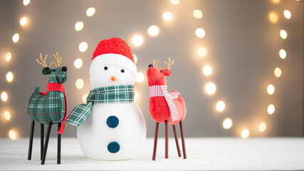 Snowman and deers or reindeers. Decoration for Christmas. White led lights bokeh on background....