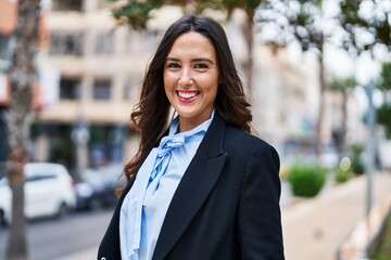 Young hispanic woman smiling confident standing at street