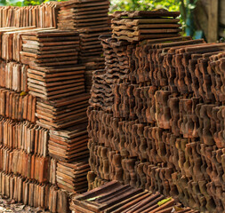 Long receding row of red roof tiles stacked