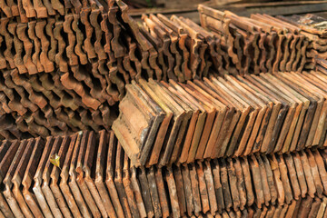 Long receding row of red roof tiles stacked