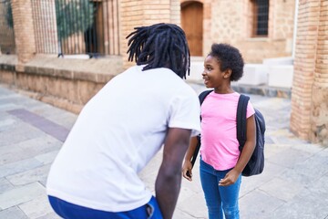 Father and daughter standing together speaking at school